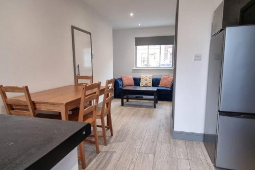 cocina y comedor con mesa y nevera en 2 BED 2 BATH & FREE PARKING - 10 MINS TO MADEJSKI STADIUM en Theale