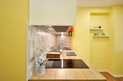 a kitchen with a sink and yellow walls at RH Charming Apartment Liberdade II in Braga