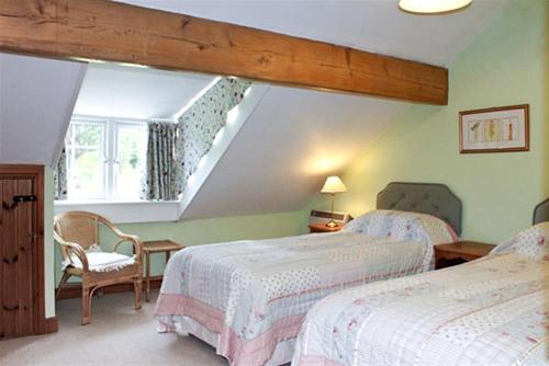 een slaapkamer met 2 bedden en een trap bij Rowan Cottage in Hawkshead