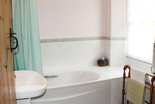 een badkamer met een bad, een toilet en een wastafel bij Rowan Cottage in Hawkshead