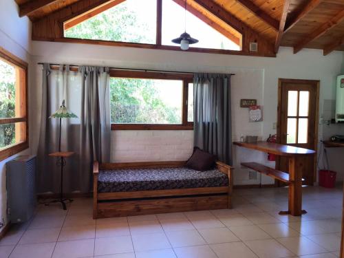 um quarto com uma cama, uma janela e uma mesa em Casa Peral em El Bolsón