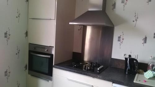 une cuisine avec une cuisinière et un micro-ondes dans l'établissement Jolie maison atypique à Montrichard, à Montrichard