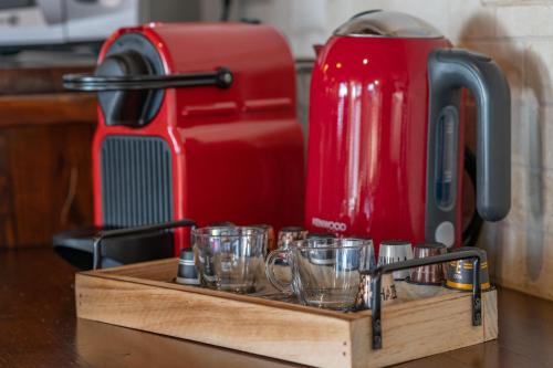 a wooden tray with glasses and a red coffee maker at דובדבן בגולן in Had Nes