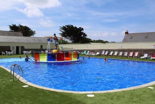 a large swimming pool with people in the water at Summer Breeze in Bude