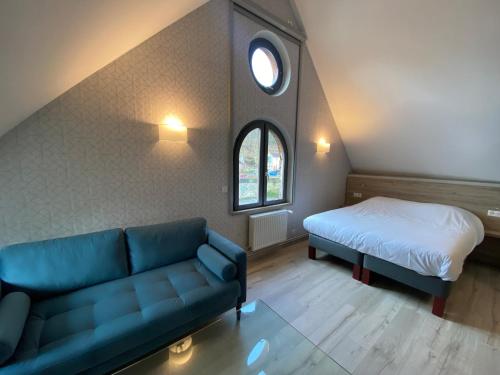 sala de estar con sofá y cama en L'Escale du Vexin, en Chaumont-en-Vexin
