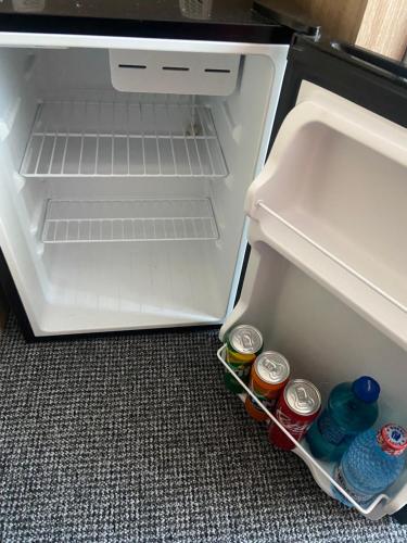 - un réfrigérateur ouvert avec des boissons à la porte dans l'établissement Garsoniera Riviera, à Bacău
