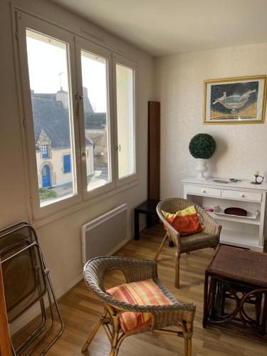 a living room with two chairs and a window at appartement spacieux et lumineux proche de la plage in Quimiac