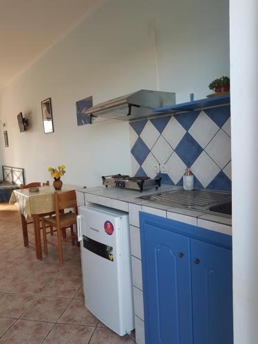 una cocina con una estufa azul y blanca y una mesa en Villasabella, en Laganas