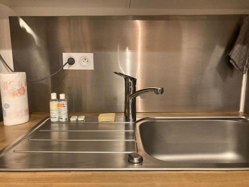 a stainless steel kitchen sink with a faucet at Appartement standing 6 personnes Disneyland Paris in Serris