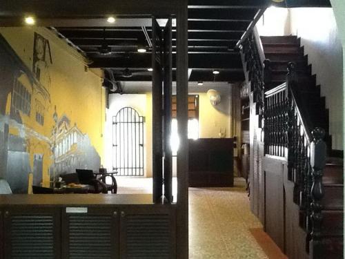 a hallway of a building with a staircase and a room at Phuket Sunny Hostel in Phuket Town