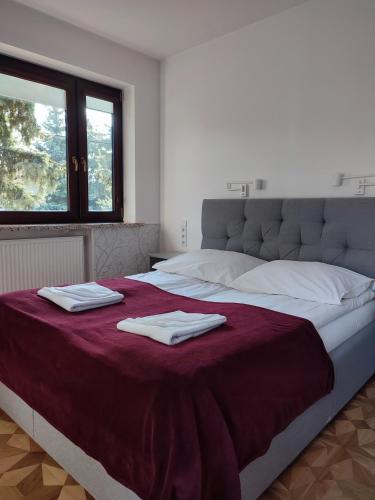 a bedroom with a large bed with towels on it at WILLA BAJLAND in Warsaw