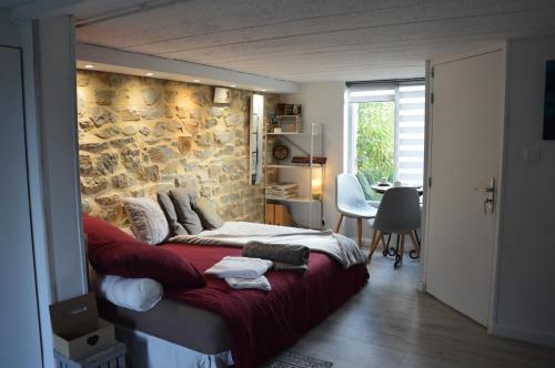 sypialnia z łóżkiem i kamienną ścianą w obiekcie Studio Galerie w mieście Chantepie