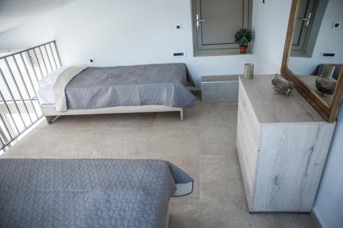 a bedroom with a bed and a mirror at Evgoro - Infinite View in Tsoútsouros