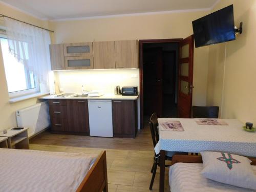 ein kleines Zimmer mit 2 Betten und einer Küche in der Unterkunft KAJA Zawoja in Zawoja