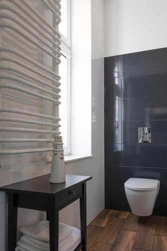 a bathroom with a toilet and a table and a window at Apartamenty Przy Plaży in Sopot