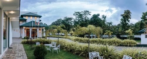 a view of a garden with white chairs and tables at Lakegala Resort in Matale