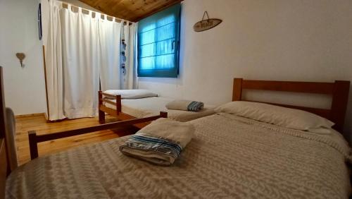 Un dormitorio con dos camas individuales y una ventana. en El Abejaruco, en Tarifa