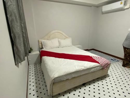 een slaapkamer met een bed met een rode en witte deken bij OYO 75396 Look Shine Apartment in Bangkok