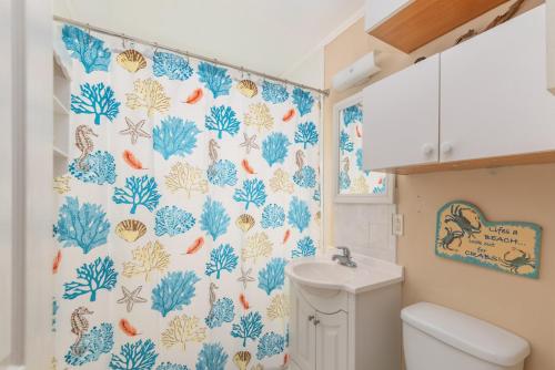baño con cortina de ducha azul y blanco en Palmwood Paradise en Tybee Island