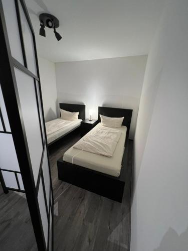 two beds in a small room with a window at E & N Apartments in Oberhausen