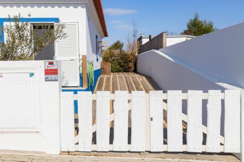 a white fence in front of a house at Villa Nova in Comporta