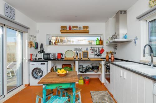 a kitchen with a sink and a table in it at Villa Nova in Comporta