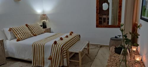 een slaapkamer met een bed, een stoel en een spiegel bij Beldicolors in Marrakesh
