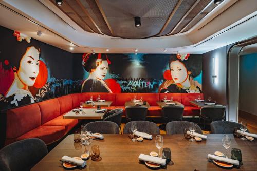 a restaurant with tables and red couches and paintings at Der LIPPISCHE HOF in Bad Salzuflen