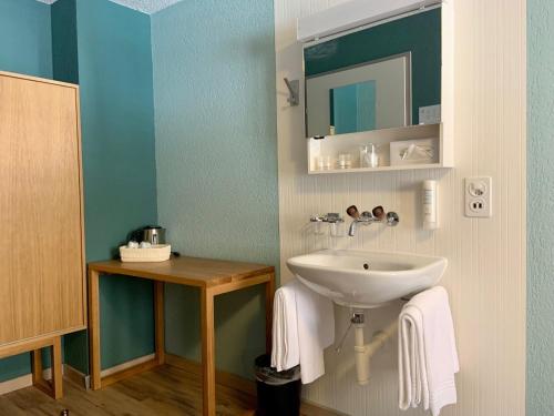 a bathroom with a sink and a mirror at 5th Floor Basic Rooms - shared bathrooms in Interlaken