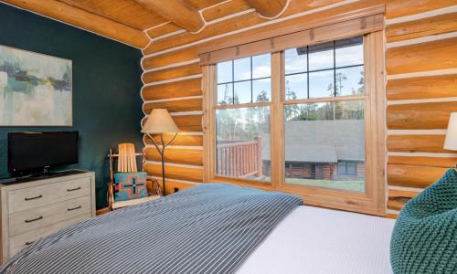 a bedroom with a bed and a large window at Powder Ridge Cabin - 9A Red Cloud in Big Sky