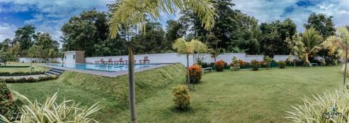 a garden with a swimming pool and trees at Lakegala Resort in Matale