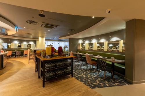 a restaurant with tables and chairs and a bar at Holiday Inn London - Regent's Park by IHG in London