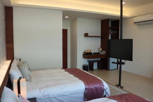 a bedroom with a bed and a flat screen tv at Sky Ocean in Yilan City