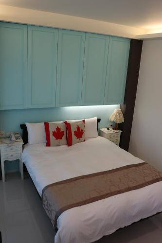 a bedroom with a large white bed with red pillows at Sky Ocean in Yilan City