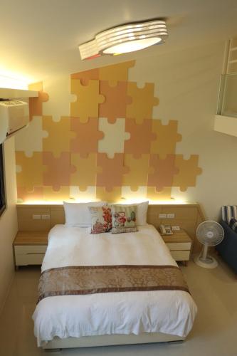 a bedroom with a large bed with a puzzle wall at Sky Ocean in Yilan City