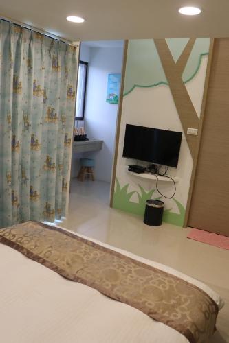 a bedroom with a bed and a flat screen tv at Sky Ocean in Yilan City