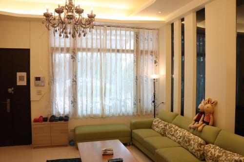 a living room with a green couch and a chandelier at Sky Ocean in Yilan City