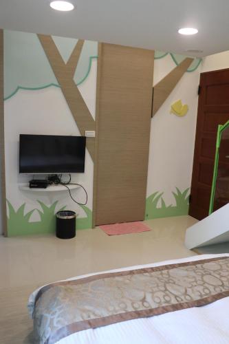 a bedroom with a wall with a tv and a bed at Sky Ocean in Yilan City