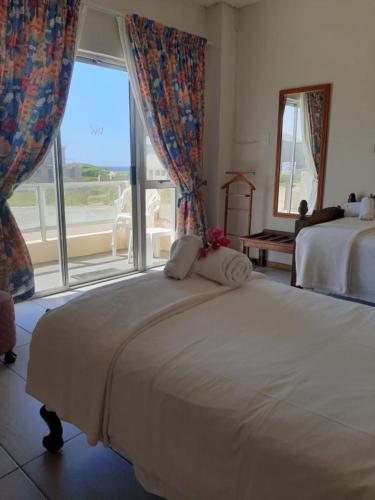 
a bedroom with a bed and a window at Whale Watchers Inn in Witsand
