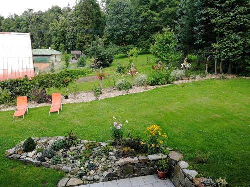 a garden with chairs and flowers in a yard at Vila U Parku in Jeseník
