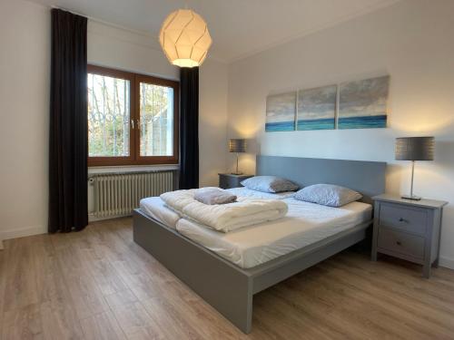 Un dormitorio con una cama grande y una ventana en Villa Holgenbach - Penthouse- und Ferienwohnung im Nationalpark Eifel, en Schleiden