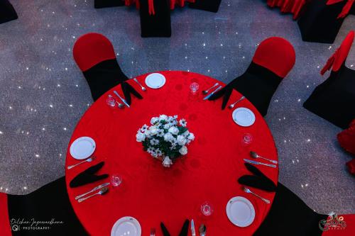 a red table with a bouquet of flowers on it at Lakegala Resort in Matale