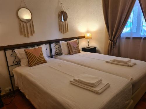 ヴィラモウラにあるAldeia do Golf - Vila I8のベッドルーム1室(ベッド2台、タオル付)