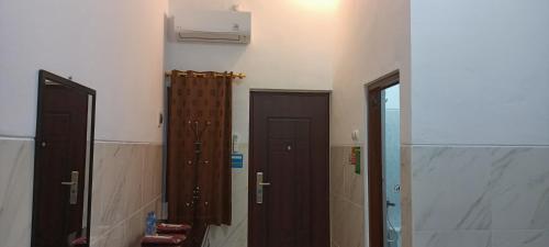 a bathroom with two brown doors and a mirror at Homestay Premium 56 in Jepara
