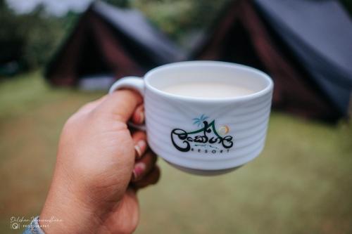 a person holding a coffee cup in their hand at Lakegala Resort in Matale