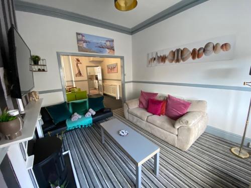 a living room with a couch and a table at Blackpool Abode - Seaside Cove in Blackpool