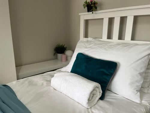 a white bed with a green and white pillow at Three Bedroom City Home with Garden in Southampton