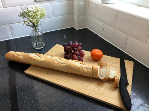 a cutting board with a knife and a bunch of grapes at Three Bedroom City Home with Garden in Southampton