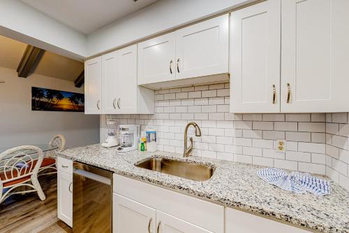 a kitchen with white cabinets and a sink at Seascape Golf Villas 11G in Destin