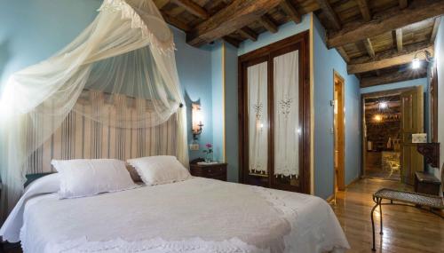 a bedroom with a white bed with a canopy at O Muiño de Pena in O Pino 